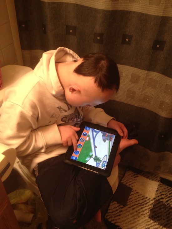 Wordless Wednesday - Down syndrome - More Alike Than Different - C with the Ipad on the Toilet